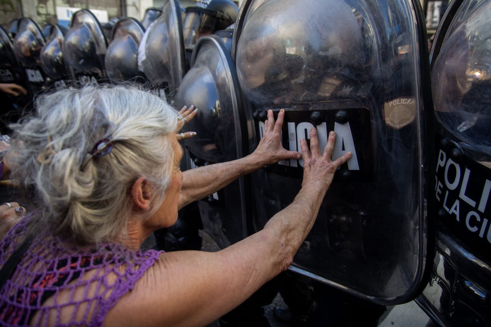 Una jubilada apoya las manos sobre los escudos de la Policía de la Ciudad durante la marcha frente al Congreso Nacional, en Buenos Aires, Argentina, el 8 de octubre de 2025.