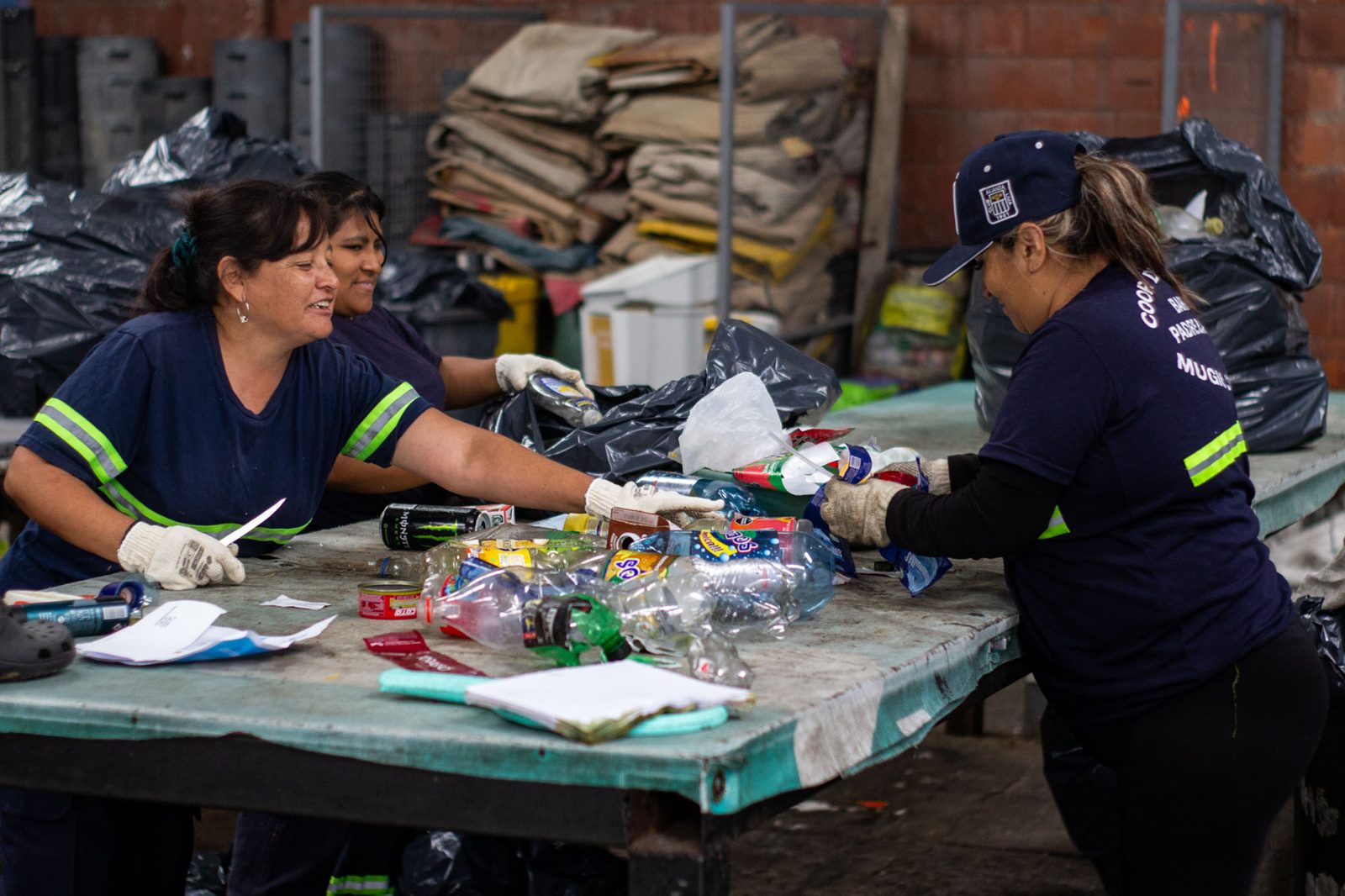 Trabajadoras de la cooperativa ATR separan envases de plástico en una mesa de clasificación, en el Barrio Mugica, Buenos Aires, Argentina, el 27 de octubre de 2025.