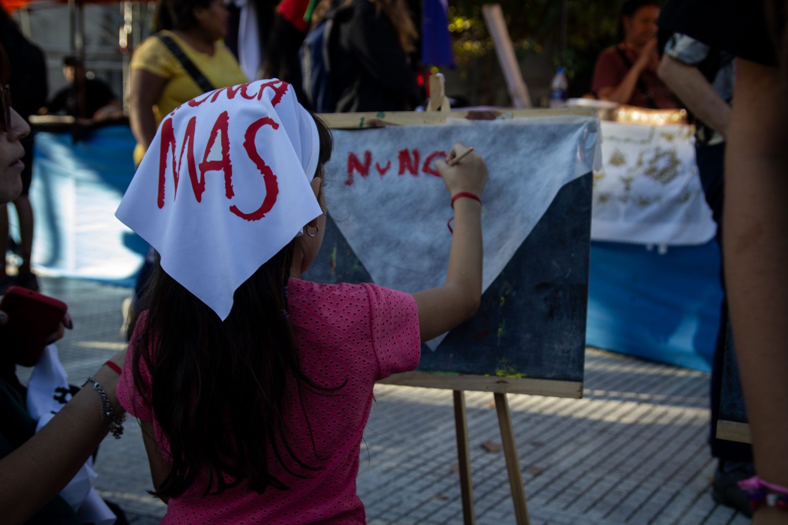 Una nena con un pañuelo blanco pinta un cartel en la Plaza de Mayo, en la víspera del 50.º aniversario del golpe de Estado, en Buenos Aires, Argentina, el 23 de marzo de 2026.