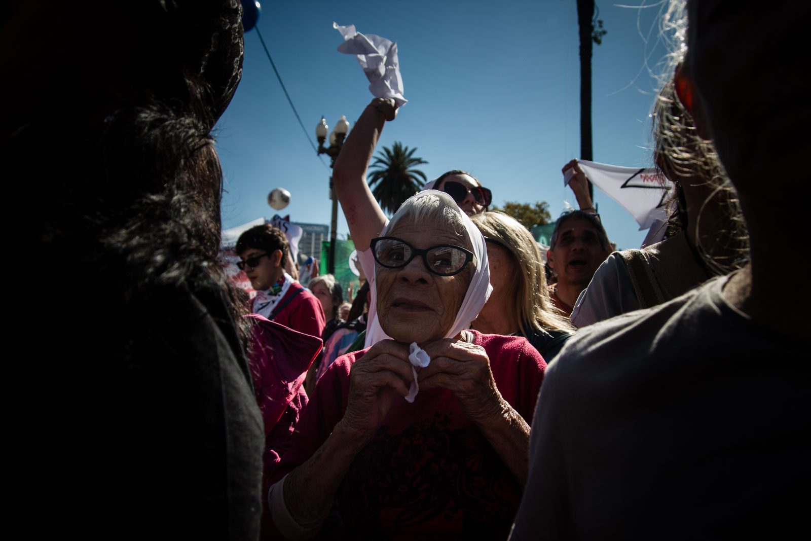 Una mujer se ata el pañuelo blanco entre la multitud que colma la Plaza de Mayo, en Buenos Aires, Argentina, el 24 de marzo de 2026.